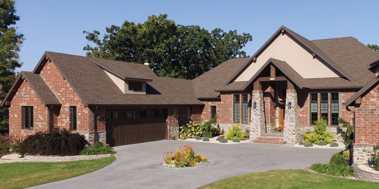Classic stone estate with dark architectural shingles